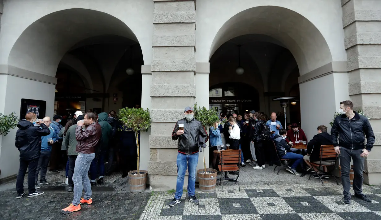 Orang-orang menikmati minum bir di teras restoran di Praha, Republik Ceko, Senin, (11/5/2020). Republik Ceko mengambil langkah normal di tengah pandemi coronavirus dengan melonggarkan lebih banyak pembatasan yang diadopsi oleh pemerintah untuk menampungnya. (AP/Petr David Josek)