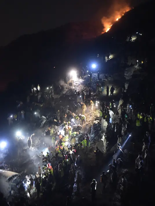 Tentara dan relawan mencari korban di antara puing pesawat Pakistan International Airlines yang jatuh di Abbottabad, wilayah Khyber Pakhtunkhawa, Rabu (7/12). Pesawat dengan nomor penerbangan PK661 itu jatuh saat mengudara ke Islamabad (AAMIR QURESHI/AFP)