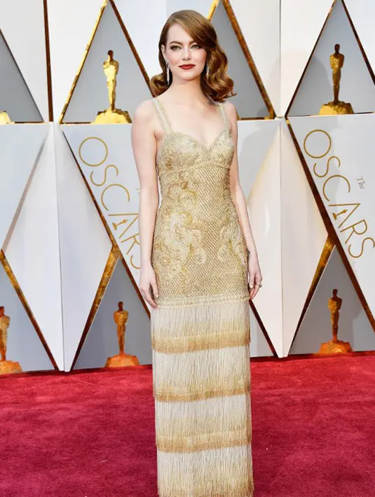 Emma Stone, si pemenang Best Actress ini tampil sederhana dengan balutan dress tanpa lengan yang berwarna emas. Rambut blondenya dibiarkan terurai dan sedikit di-curly dengan lipstick merah yang berhasil memikat hati orang yang melihat. (AFP/Bintang.com)