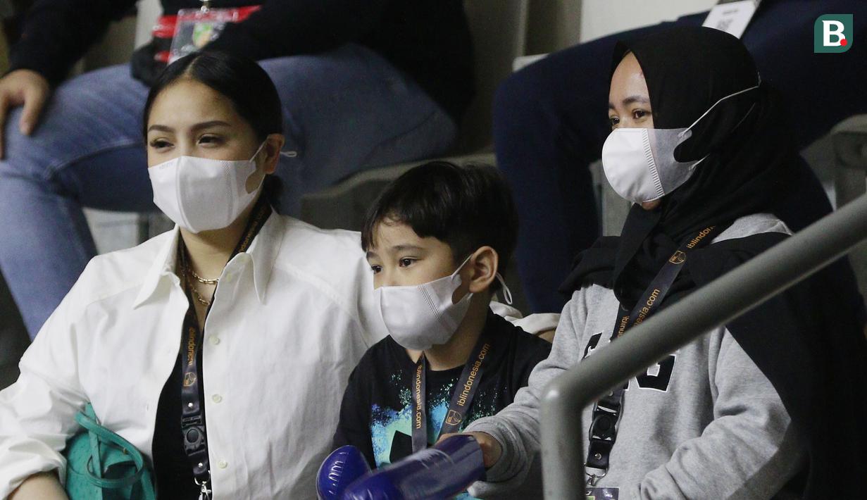 Artis, Nagita Slavina dan anaknya Rafathar saat menonton pertandingan Satria Muda Pertamina melawan Rans PIK Basketball pada laga IBL 2022 di Hall Basket GBK, Jakarta, Rabu (19/01/2022). Satria Muda menang dengan skor 64-32. (Bola.com/M Iqbal Ichsan)