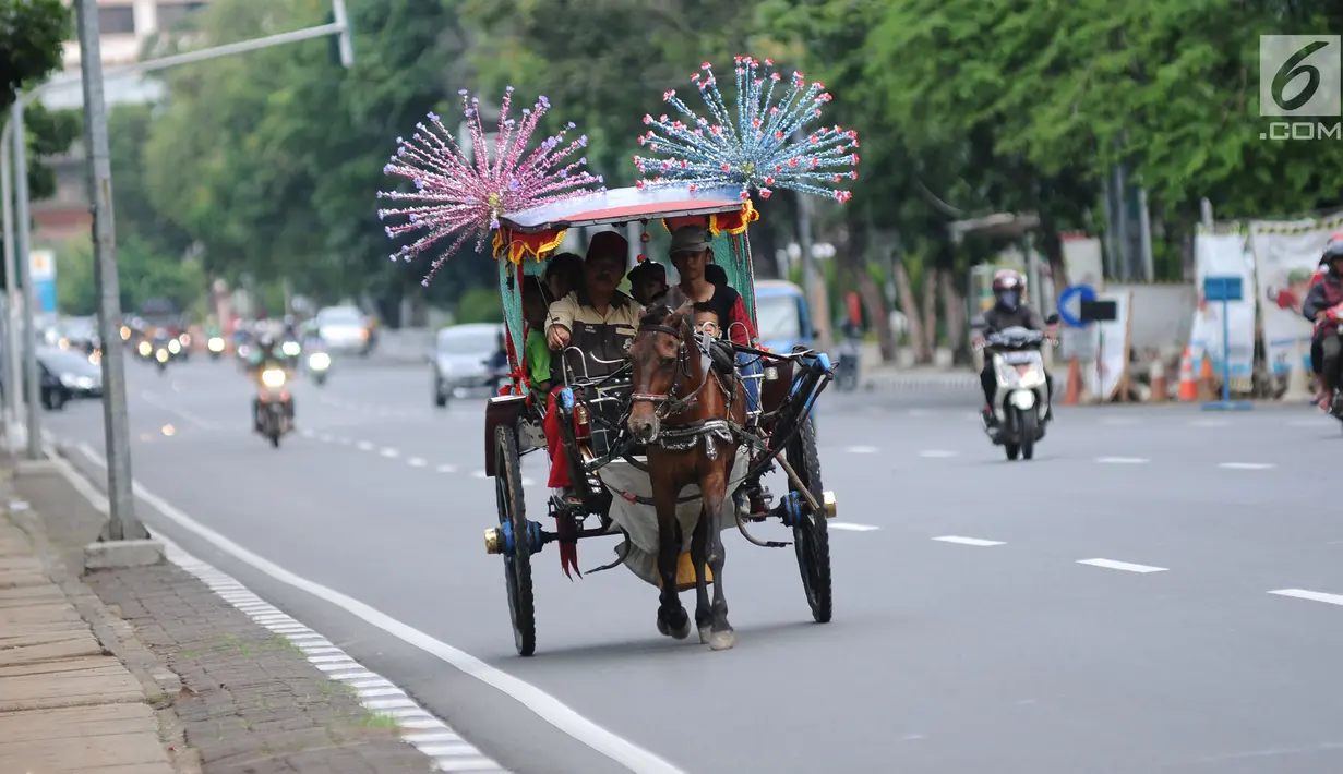 Delman hias membawa penumpang melintasi Jalan Medan Merdeka Selatan di luar kawasan Monas, Jakarta, Selasa (26/12). Pemprov DKI Jakarta menguji coba kembali beroperasinya delman hias di luar kawasan Monas, Jakarta. (Liputan6.com/Helmi Fithriansyah)