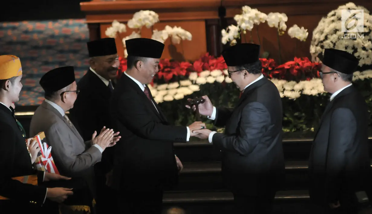 Mantan Ketua DPRD DKI Jakarta Prasetyo Edi Marsudi menyerahkan palu jabatan kepada Ketua DPRD DKI Jakarta Sementara, Pantas Nainggolan saat pelantikan anggota DPRD DKI Jakarta yang terpilih dalam Pemilu 2019 di Gedung DPRD DKI Jakarta, Senin (26/8/2019). (merdeka.com/Iqbal S Nugroho)