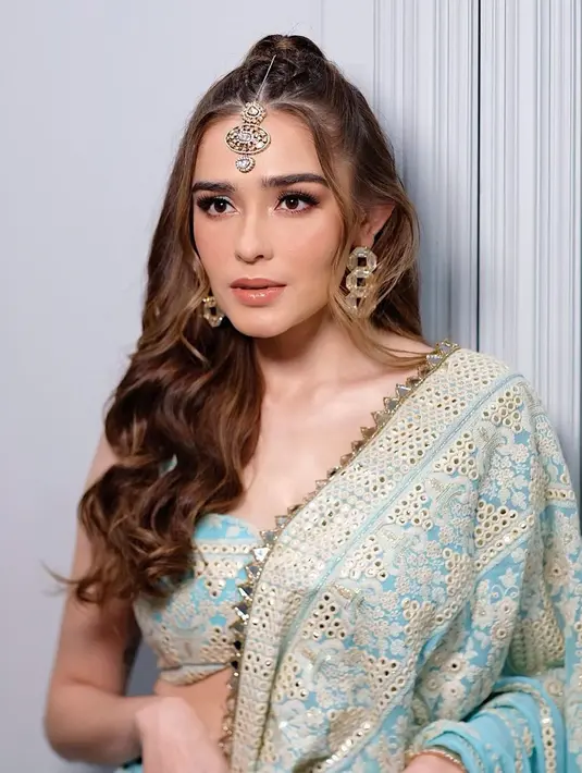 Ia kenakan kain sari warna biru pastel dan emas dengan bra berwarna senada yang pamerkan perut rata [@yaswildblood]