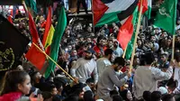 Para tahanan bersorak di antara para pendukungnya setelah dibebaskan dari penjara Israel di Ramallah, Tepi Barat yang diduduki, pada tanggal 26 November 2023. (Jaafar ASHTIYEH/AFP)
