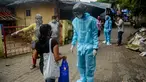 Sukarelawan petugas kesehatan dari LSM India Bharatiya Jain Sanghatana mengenakan helm pintar untuk melakukan screening kasus COVID-19 dari pintu ke pintu di Mumbai, 21 Juli 2020. Alat tersebut memungkinkan petugas Kesehatan mencatat suhu puluhan penduduk per menit. (INDRANIL MUKHERJEE/AFP)