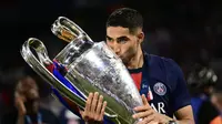 Achraf Hakimi mencium trofi Liga Champions usai membawa PSG mengalahkan Inter Milan. (Marco BERTORELLO / AFP)