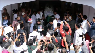 Sejumlah pelayat bersiap menggotong jenazah Ketua KPU Husni Kamil Manik usai disalatkan di Kompleks KPU, Jakarta, Jumat (8/7). Husni Kamil Manik wafat diusia 40 tahun pada Kamis malam (7/7). (Liputan6.com/Helmi Fithriansyah)