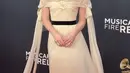 Gracie Abrams tampil dengan gaun bak pengantin warna kuning soft. Gaun dari Channel ini memiliki model off shoulder dan bunga di bagian dada serta belt hitam. Dan yang menarik tudung kepala transparan yang ia kenakan. Membuat gaun tudung ini menjadi tren. [@voguemagazine]