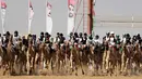 Sejumlah joki menunggangi untanya saat mengikuti lomba balap unta di festival unta Sheikh Sultan Bin Zayed al-Nahyan di arena pacuan shweihan di al-Ain di pinggiran Abu Dhabi (2/2). (AFP Photo/Karim Sahib)