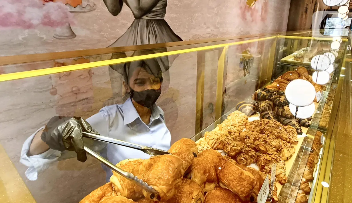 Pramusaji menyiapkan makanan berupa roti di sela-sela pembukaan Restoran La Verre Patisserie di Pondok Indah Mall (PIM) 1 Jakarta, Senin (21/3/2022). Restoran bergaya fancy dan classy berdesain arsitektur dekoratif modern menjadi pelengkap gaya hidup masyarakat urban. (Liputan6.com/Fery Pradolo)