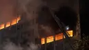 Petugas pemadam kebakaran berusaha memadamkan api yang melahap bangunan 26 lantai di Sao Paulo, Brasil, Selasa (1/5). Bangunan tersebut bahkan roboh dan ambruk setelah dilalap si jago merah. (AP/Andre Penner)