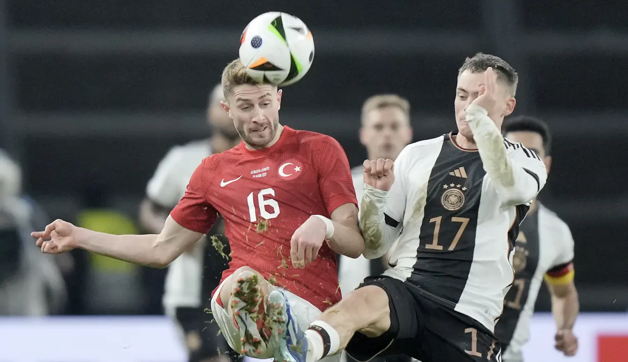 Gelandang Turki Ismail Yuksek berebut bola dengan gelandang JermanFlorian Wirtz dalam laga uji coba di Olympiastadion, Berlin, Minggu (19/11/2023) dini hari WIB. (AP Photo/Markus Schreiber)