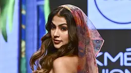 Rhea Chakraborty berjalan di catwalk mengenakan kreasi desainer Guapa selama FDCI X Lakme Fashion Week di Mumbai pada 14 Oktober 2022. Aktris itu menampilkan tampilan pengantin pantai yang sempurna saat dia berjalan dengan kerudung bermotif bunga yang serasi. (AFP/Sujit Jaiswal)