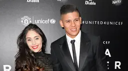  Bek Manchester United, Marcos Rojo (kanan) dan pacarnya Eugenia Lusardo berpose di atas karpet merah saat tiba untuk menghadiri "Inggris untuk UNICEF Gala Dinner" di Old Trafford, Manchester, Inggris, (29/11). (AFP PHOTO/OLI SCARFF)