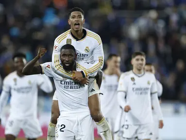 Pemain Real Madrid, Antonio Rudiger dan Jude Bellingham merayakan kemenangan tim mereka saat melawan Deportivo Alaves pada laga La Liga 2023/2024 jornada 18 di Estadio Mendizorroza, Jumat (22/12/2023) dini hari WIB. (AP Photo/Ricardo Larreina)