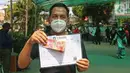 Warga penerima bantuan menunjukkan uang tunai saat penyaluran Bantuan Sosial Tunai (BST) di kawasan Kelurahan Kembangan, Meruya, Jakarta Barat, Minggu (25/07/2021). Penyaluran BST tersebut diperkirakan akan rampung pada 7 Agustus 2021 mendatang. (Liputan6.com/Herman Zakharia)