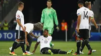 Jerome Boateng (tengah) mendapat perawatan saat membela Jerman kontra Prancis, pada laga semifinal Piala Eropa 2016, di Stade Velodrome, Marseille (7/7/2016). Boateng terbang ke Amerika Serikat, bergabung dengan armada Bayern Munchen.  (Reuters/Michael Da