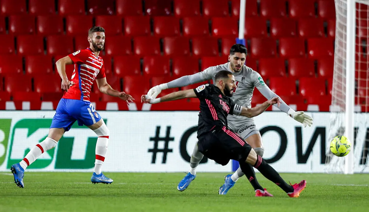 Pemain Real Madrid Karim Benzema mencetak gol ke gawang Granada pada pertandingan La Liga di Stadion Los Carmenes, Granada, Spanyol, Kamis (13/5/2021). Real Madrid menang telak 4-1 atas Granada. (AP Photo/Fermin Rodriguez)