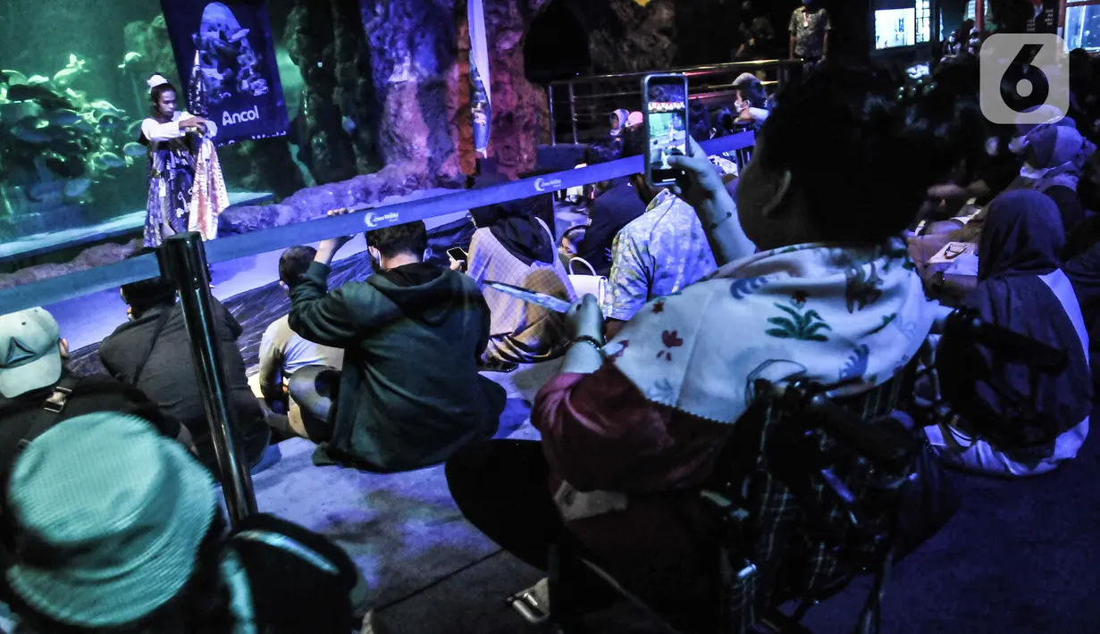 Pengunjung menyaksikan pertunjukan peragaan busana batik di Sea World Ancol, Jakarta Utara, Rabu (28/9/2022). Sea World Ancol menggelar pertunjukkan bertajuk "Pekan Kolaborasi Budaya dan Sejarah" untuk menyambut peringatan Hari Batik Nasional Tahun 2022 yang akan berlangsung pada tanggal 1-9 Oktober 2022 dengan menampilkan fashion show, tarian tradisional serta atraksi bawah air. (merdeka.com/Iqbal S. Nugroho)