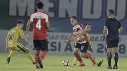 Gelandang Madura United, Slamet Nurcahyo, berusaha melewati Gelandang Bhayangkara FC, Wahyu Suboseto, pada laga Liga 1 di Stadion PTIK, Jakarta, Kamis, (07/6/2018). Bhayangkara FC menang 1-0 atas Madura United. (Bola.com/M Iqbal Ichsan)