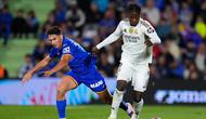 Pemain Getafe, Mario Martin (kiri), dan pemain Real Madrid, Eduardo Camavinga, berebut bola dalam pertandingan La Liga antara Getafe&nbsp;vs Real Madrid, 19 Oktober 2025. (AP Photo/Manu Fernandez)
