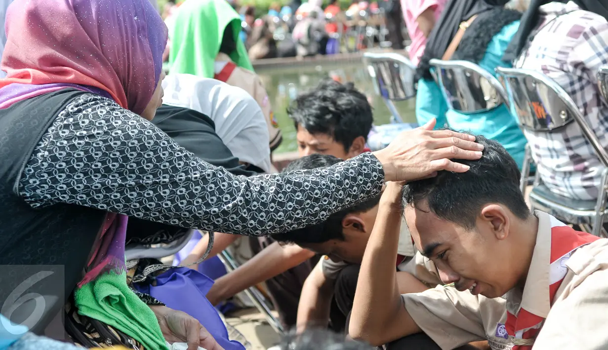 Anggota Kwarnas Gerakan Pramuka menangis sambil membasuh kaki ibunya di Taman Wiladatika Cibubur, Jakarta, Rabu (21/12). Memperingati Hari Ibu 2016, Kwarnas Gerakan Pramuka menggelar kegiatan "Membasuh Kaki Ibu" secara massal . (Liputan6.com/Yoppy Renato)