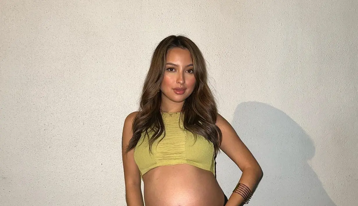 Penampilan manis Jennifer Coppen pamer baby bump. Cropped top hijau tanpa lengan dipadunya mengenakan rok hitam dengan high-slit. [Foto: Instagram/jennifercoppenreal20]