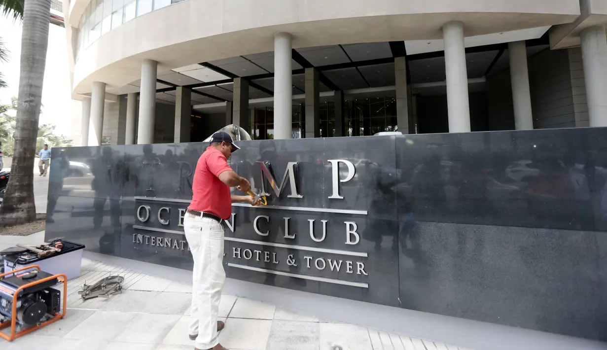 Pekerja mencopot nama 'Trump' dari papan sebuah hotel mewah di Panama, Senin (5/3). Pengusaha Siprus Orestes Fintiklis yang memiliki saham mayoritas hotel tersebut mengatakan, terjadi sengketa komersial yang tak terkendali. (AP/Arnulfo Franco)