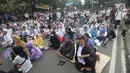 Massa berkumpul menyampaikan pendapat terkait sidang perselisihan hasil pilpres 2019 di sekitar Patung Arjuna Wiwaha Jalan Medan Merdeka Barat, Jakarta, Jumat (14/6/2019). Massa meminta sidang berlangsung adil. (Liputan6.com/Helmi Fithriansyah)