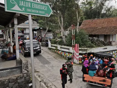 Penduduk desa menggunakan mobil bak terbuka dievakuasi dari rumah mereka di lereng Gunung Merapi, di Krinjing, Jawa Tengah, Jumat (6/11/2020). Evakuasi dilakukan bagi warga lereng Merapi menyusul peningkatan status aktivitas vulkanik gunung tersebut. (AP Photo/Taufiq Rozzaq)