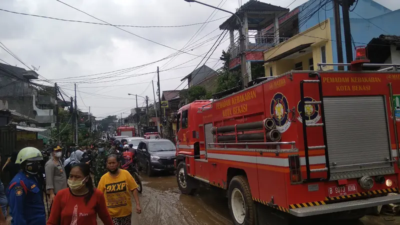 Petugas gabungan membersihkan lumpur akibat banjir di Perumahan Pondok Gede Permai, Jatiasih, Kota Bekasi