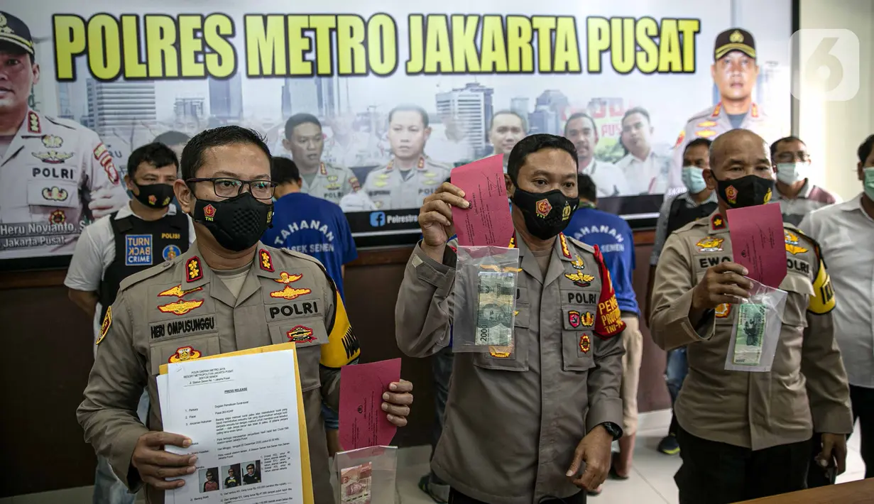 Kapolres Jakarta Pusat Kombes Pol Heru Novianto menunjukkan bukti kasus pemalsuan surat hasil rapid test COVID-19 di Mapolres Jakarta Pusat, Minggu (20/12/2020). Polisi menangkap tiga tersangka beserta bukti uang hasil transaksi pemalsuan surat hasil rapid test COVID-19. (Liputan6.com/Faizal Fanani)