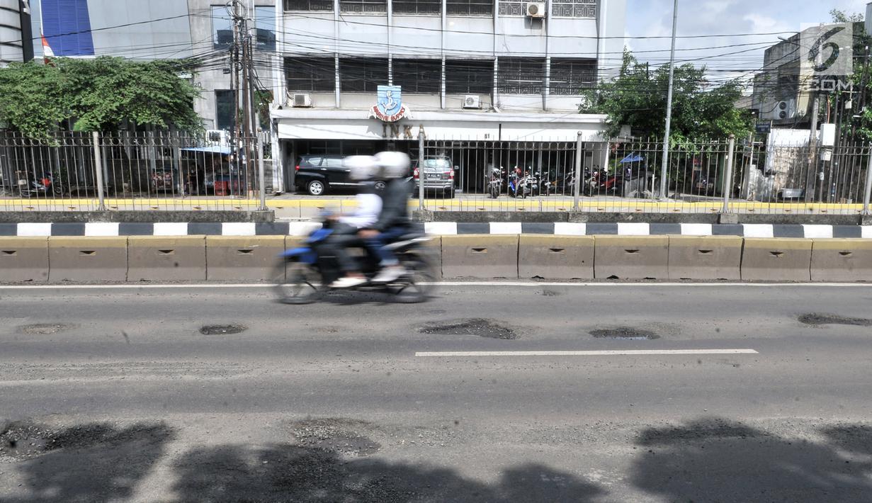 Pengendara motor menghindari jalan berlubang saat melintasi kawasan Gunung Sahari, Jakarta, Selasa (29/1).  Jalan rusak dan berlubang di sepanjang Jalan Gunung Sahari tersebut dapat membahayakan pengendara yang melintas. (Merdeka.com/Iqbal S. Nugroho)