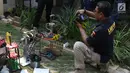 Petugas melakukan olah TKP barang bukti alat pencetak pil ekstasi di sebuah perumahan di Kawasan Pondok Rajeg, Cibinong, Jawa Barat, Senin (24/9). Polisi juga menahan tiga tersangka dan sejumlah barang bukti terkait. (Liputan6.com/Helmi Fithriansyah)