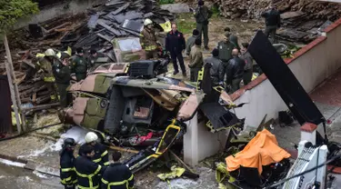Regu penyelamat dan tim penyelidik berada di lokasi jatuhnya helikopter militer di lingkungan perumahan di Istanbul, Turki, Senin (26/11). Kecelakaan helikopter tersebut menewaskan empat dari lima tentara di dalamnya. (HO / DHA / AFP)