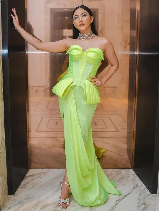 Jessica Milla berpose di depan pintu lift.  Ekspresi datar membuat penampilannya berkelas. Tata rambut klimis membuat Jessica semakin mempesona. Jessica memadankan dress tersebut dengan sepatu heels simpel berwarna silver. (Instagram/jscmila)