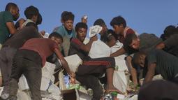 Mereka menaiki truk terbuka untuk membawa pulang paket bantuan yang terbatas jumlahnya. (AP Photo/Mariam Dagga)