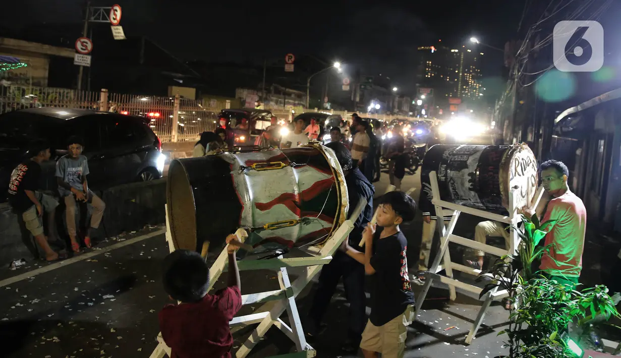 <p>Warga melakukan pukul bedug saat malam Takbiran di Jakarta, Minggu (1/5/2022). Takbiran tersebut dilakukan dalam rangka menyambut Idul Fitri 1443 H yang ditetapkan oleh pemerintah pada Senin (2/5/2022). (Liputan6.com/Angga Yuniar)</p>