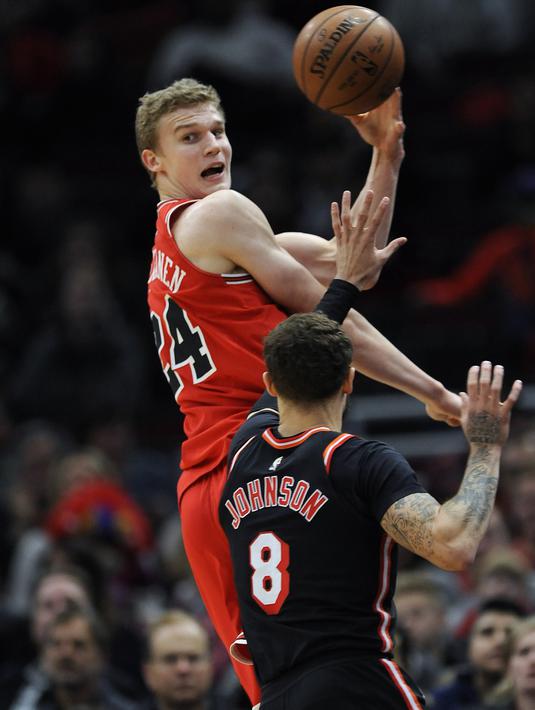 Aksi pemain Chicago Bulls, Lauri Markkanen (24) mengumpan bola saat diadang pemain Miami Heat, Tyler Johnson (8) pada laga NBA basketball game di United Center, Chicago, (26/11/2017). Miami Heat menang 100-93.  (AP/Paul Beaty)