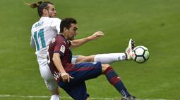 Striker Real Madrid, Gareth Bale, berebut bola dengan gelandang Eibar, Gonzalo Escalante, pada laga La Liga di Stadion Ipurua, Sabtu (10/3/2018). Eibar takluk 1-2 dari Real Madrid. (AP/Alvaro Barrientos)