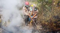 Polisi anggota Satgas Karhutla memadamkan api di hutan dan lahan yang terbakar, di Kabupaten Musi Banyuasin, Selasa (27/8/2019). (dokumentasi Polres Musi Banyuasin)