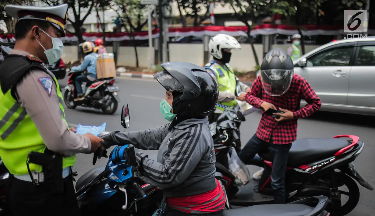 Polisi lalu lintas melakukan tilang terhadap pengendara motor saat razia Operasi Patuh Jaya 2019 di kawasan Kemanggisan, Jakarta, Kamis (29/8/2019). Diketahui, Operasi Patuh Jaya 2019 di wilayah hukum Polda Metro Jaya mulai digelar hari ini hingga 11 September 2019. (Liputan6.com/Faizal Fanani)