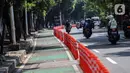 Kendaraan melintasi "stick cone" pembatas jalur sepeda di kawasan Pejompongan, Jakarta, Selasa (29/11/2022). Pemprov DKI Jakarta kembali mengganggarkan dana untuk perawatan jalur dan evaluasi pembatas sepeda pada rancangan APBD tahun anggaran 2023 sebesar Rp7,5 miliar setelah sebelumnya sempat dicoret dari anggaran dan menuai kecaman dari sejumlah pihak. (Liputan6.com/Johan Tallo)