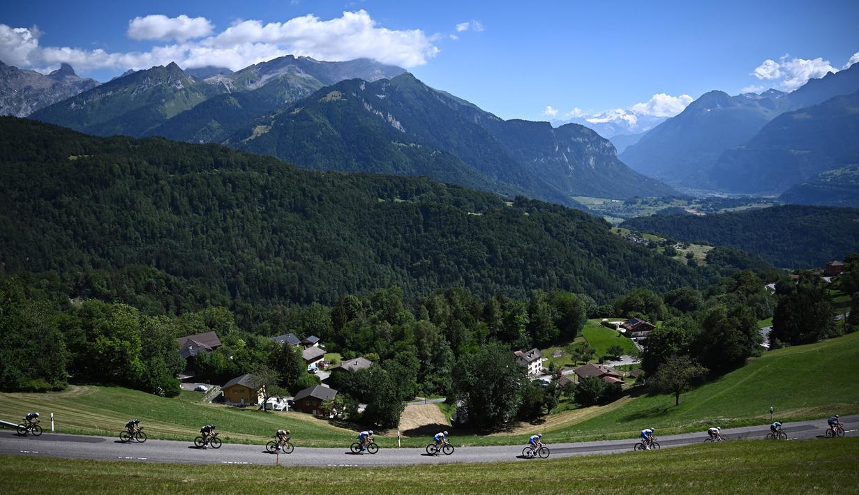 Rombongan pebalap melintas dengan latar belakang pegunungan Alpen Swiss selama etape ke-8 pada ajang balapan sepeda Tour de France 2022. (AFP/Anne-Christine Poujoulat)