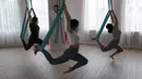 Para murid melakukan gerakan aerial yoga atau yoga udara di Aerial Jooga Studia, Kelapa Dua, Tangerang, Banten, Minggu (10/10/2021). Di masa pandemi, peminat olahraga yang berasal dari Amerika Serikat ini meningkat lebih dari 60 persen. (merdeka.com/Arie Basuki)