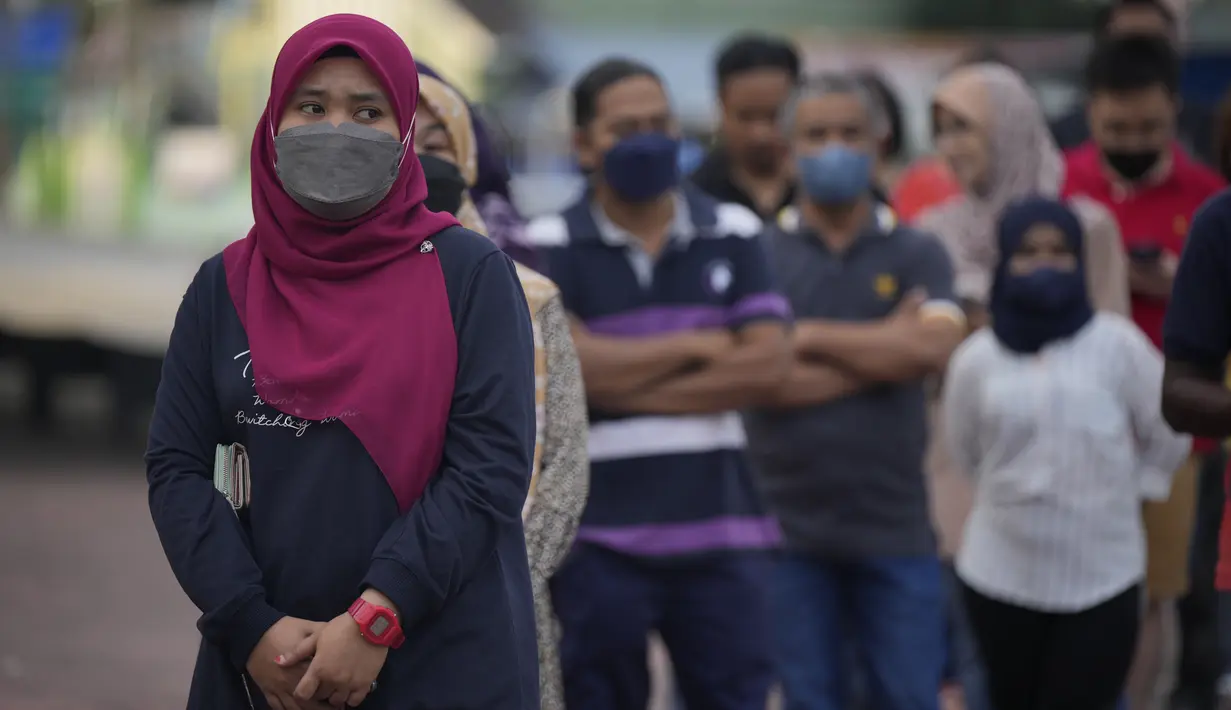 Orang-orang mengantre memasuki tempat pemungutan suara untuk memberikan suara mereka selama pemilihan di Seberang Perai, negara bagian Penang, Malaysia, Sabtu (19/11/2022). Tempat pemungutan suara di Semenanjung Malaysia akan ditutup secara bertahap dari pukul 12 siang hingga 6 sore. (AP Photo/Vincent Thian)