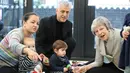 Ekspresi Perdana Menteri Inggris Theresa May saat bermain dengan bayi di pusat kesehatan di London, Inggris, Kamis (22/11). Theresa menjadi PM Inggris setelah David Cameron, PM sebelumnya, mengundurkan diri akibat Brexit. (Andrew Matthews/Pool via AP)