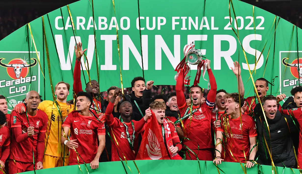 Para pemain Liverpool merayakan gelar Carabao Cup 2021/2022 setelah mengalahkan Chelsea pada laga final di Wembley Stadium, London (27/2/2022). Hingga kini Liverpool memimpin sendirian dalam perolehan trofi Piala Liga Inggris terbanyak dengan 9 kali juara. Trofi terakhir diraih The Reds pada musim 2021/2022 setelah mengalahkan Chelsea melalui adu penalti 11-10 (0-0) dalam partai final. (AFP/Justin Tallis)