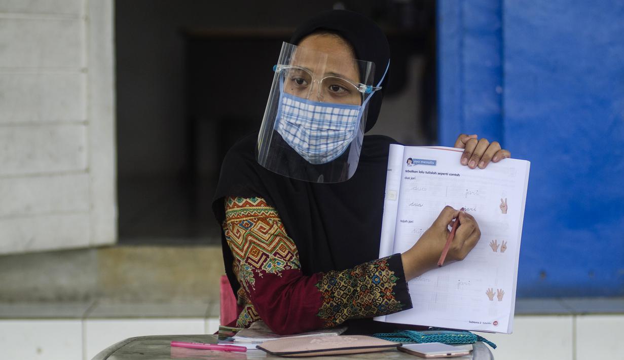 Guru mengenakan masker saat mengajar siswa SD secara tatap muka di Sekolah Islam Ibnu Aqil Ibnu Sina, Soreang, Bandung, Jawa Barat, Rabu (5/8/2020). Indonesia akan mengizinkan sekolah di zona hijau COVID-19 melakukan pembelajaran tatap muka di bawah protokol kesehatan yang ketat. (Xinhua/Septianjar)