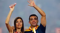 Gelandang Barcelona, Xavi Hernandes bersama istrinya menyapa pengemarnya saat parade di stadion Camp Nou, Spanyol (7/6/2015). ini merupakan musim terakhir Xavi berkostum Barcelona yang akan pindah ke klub papan atas Qatar, Al Sadd. (REUTERS/Albert Gea)